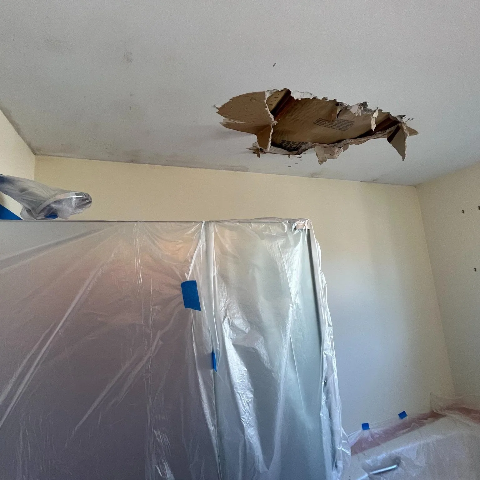 Water-damaged ceiling drywall cut out and prepared for repair
