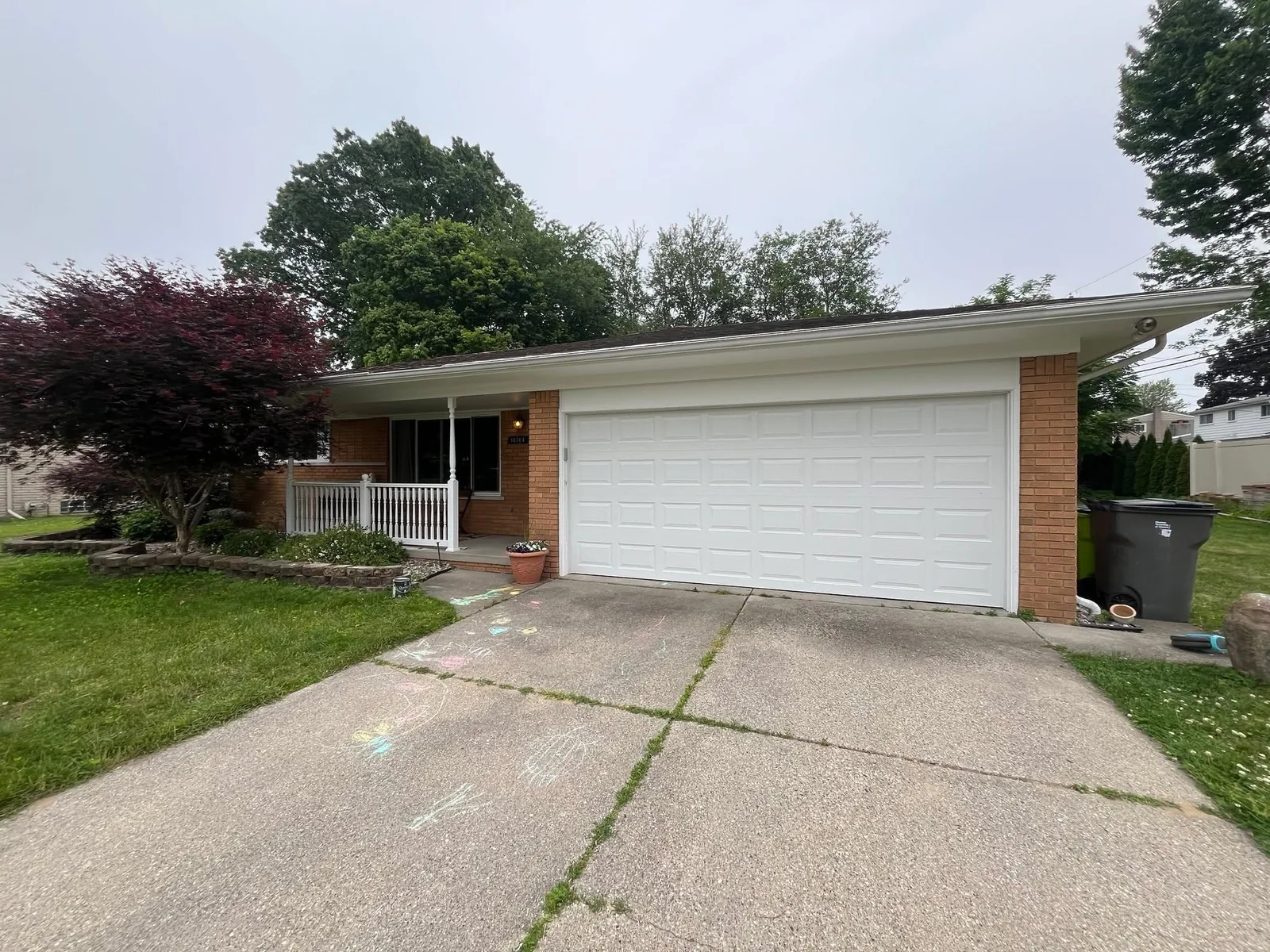 Brick ranch home with a white garage door and freshly repainted trim