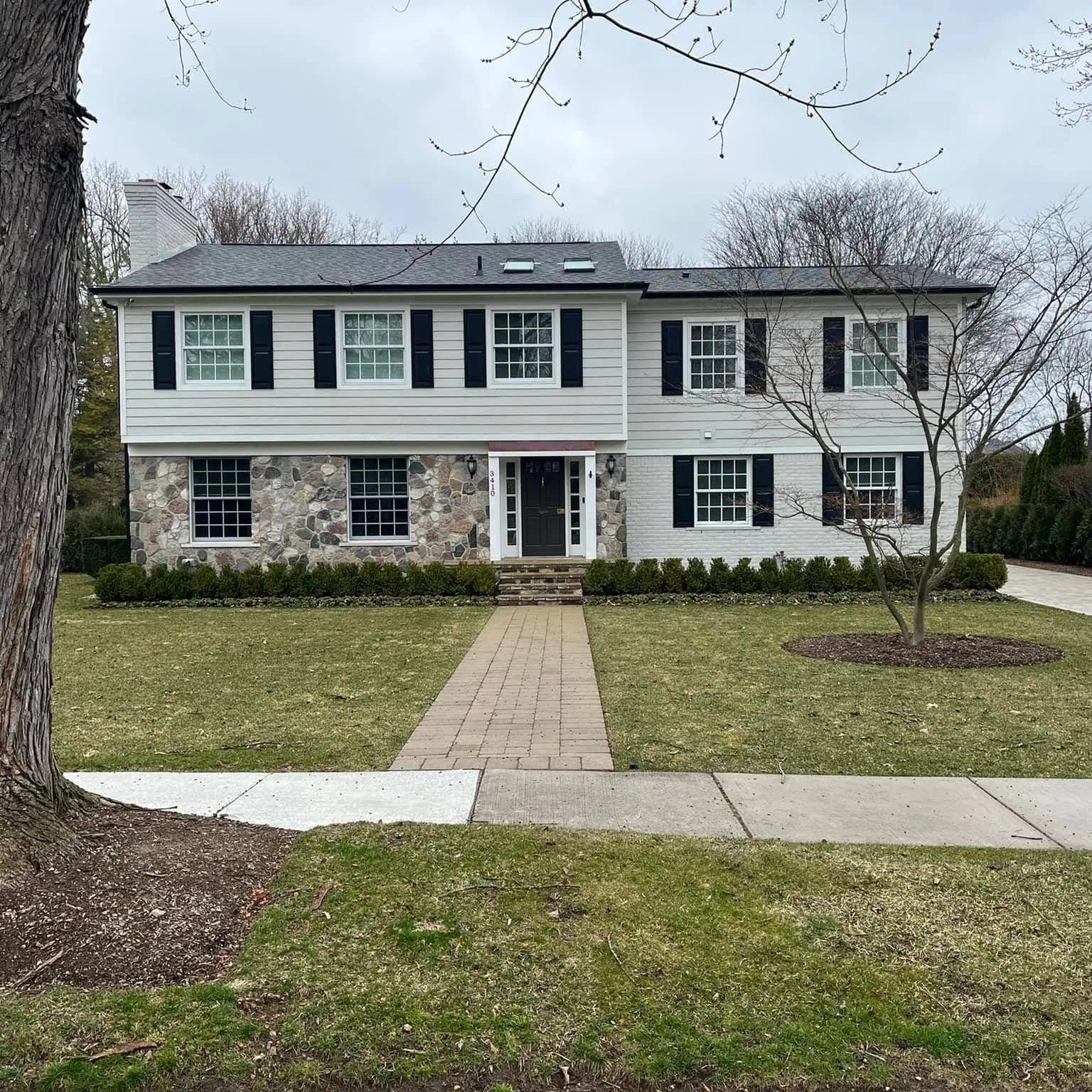 White colonial home with stone accents and freshly painted exterior trim
