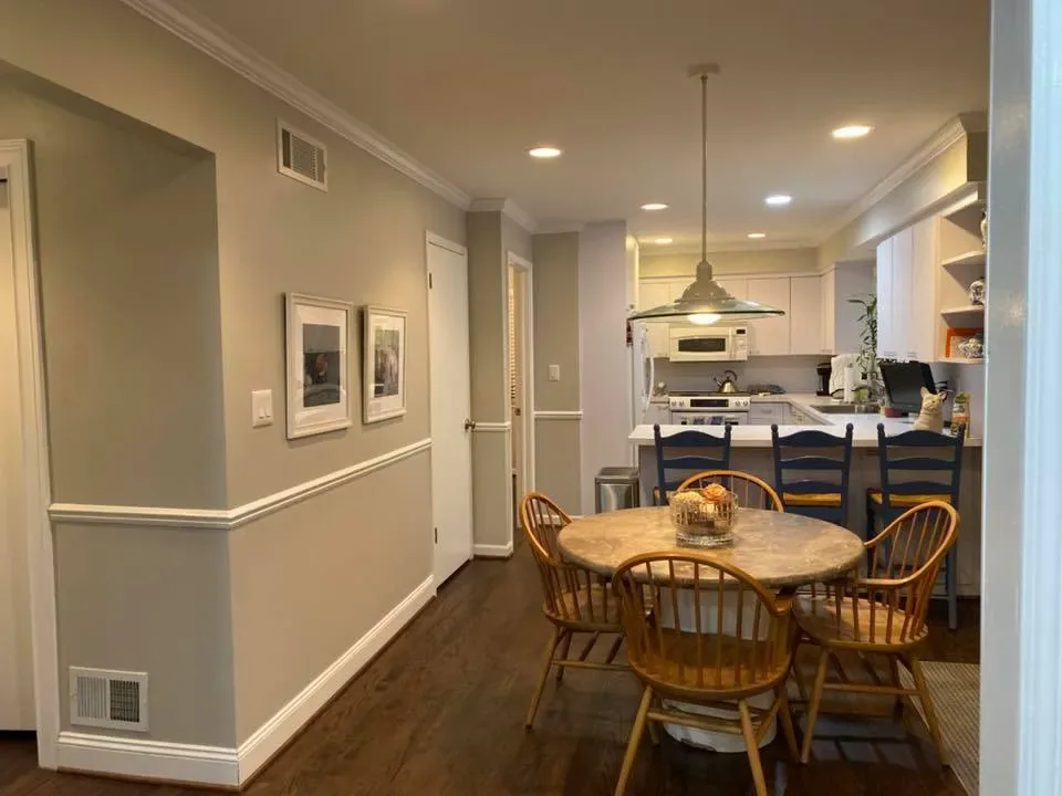 Open dining and kitchen area with two-tone painted walls and chair-rail trim