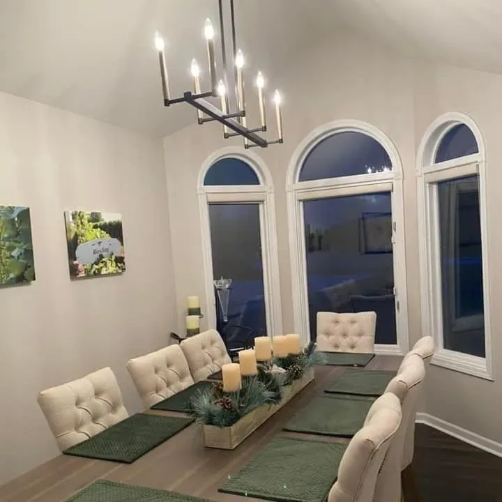 Formal dining room with smoothly painted walls, arched windows, and a chandelier