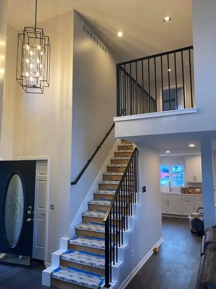 Two-story foyer and staircase with smoothly painted walls and crisp trim