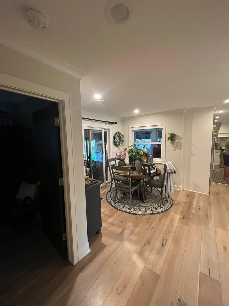 Freshly painted hallway opening into a dining area with hardwood floors