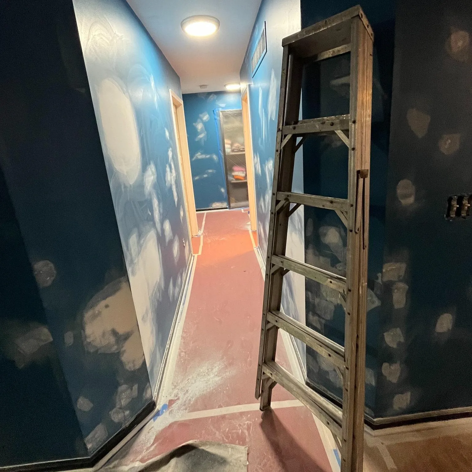 Hand-painted blue sky and clouds mural along a stairwell